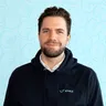 Gary Vanbutsele in a blue hoodie standing in front of a blue background raises 2.5 million.