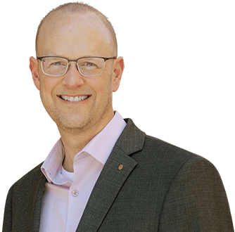 A bald man with glasses and a pink shirt is employed at SkyPort IT.