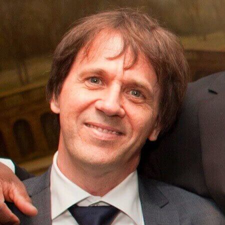 A man in a suit and tie demonstrates knowledge for the camera.