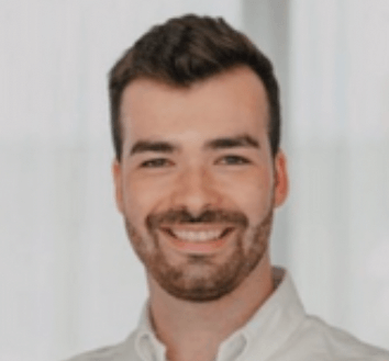 A smiling man in a white shirt, engaged in employee training and documentation.