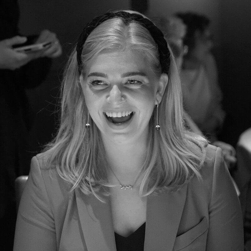A black and white photo of a woman laughing.