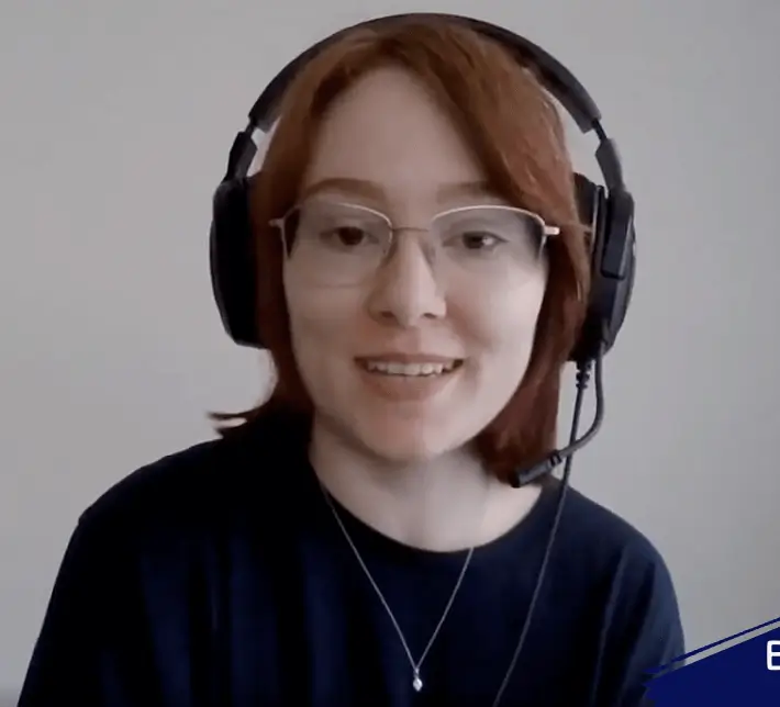 A woman wearing headphones and a t shirt, attentively engaged in employee training.