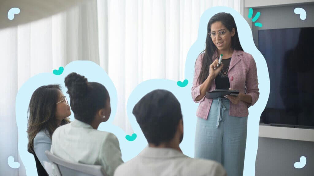 A woman holding a pen is discussing processes with a group of people.