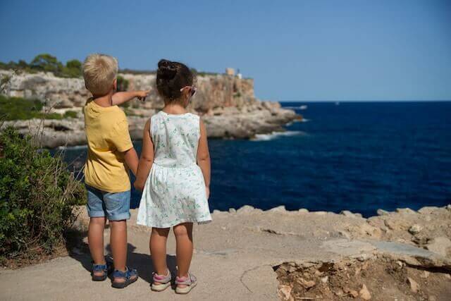 Two Visionary children standing on a cliff overlooking the Integrator™ ocean.