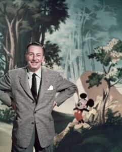 Walt Disney standing in front of a lush forest, symbolizing the interchangeable nature of the business world.