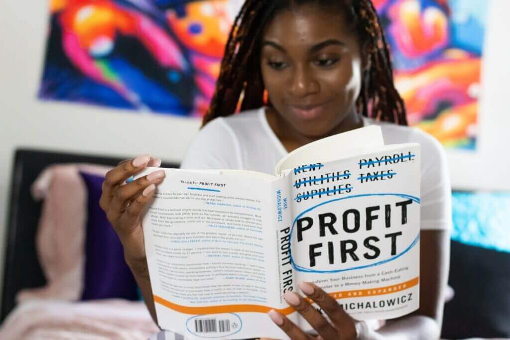 A woman reading the book profit first to learn new processes.