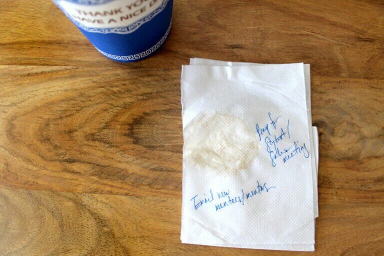 A napkin with writing on it next to a cup of coffee in a SOP.