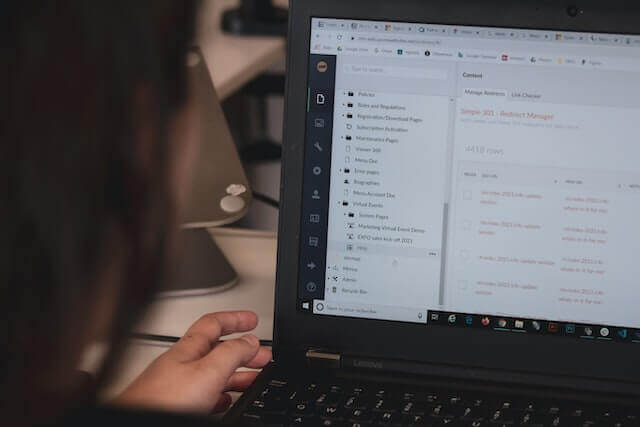 A woman is following procedures on a laptop with an app.