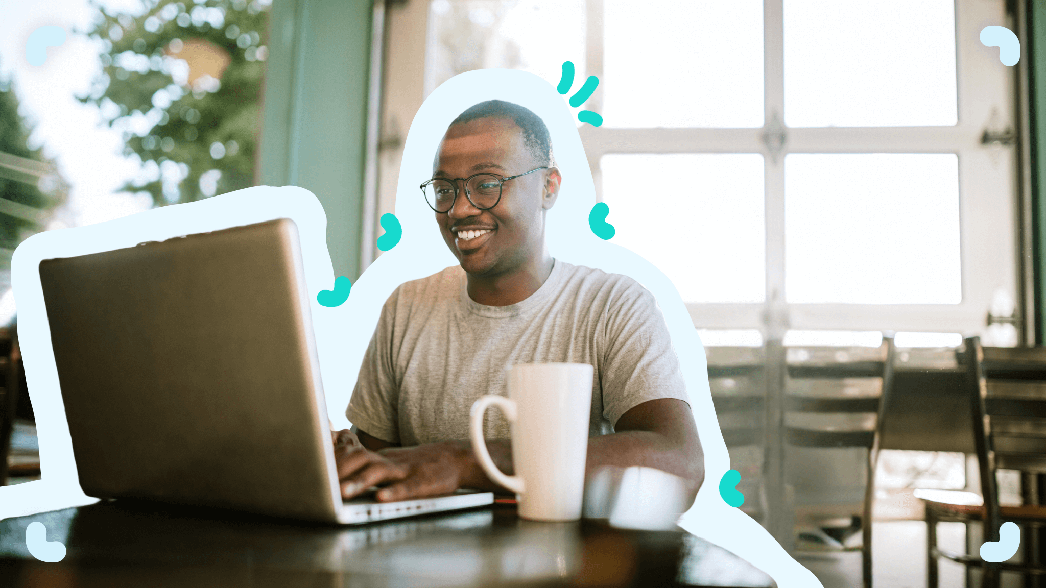 A man sitting at a table with a laptop during remote employee onboarding