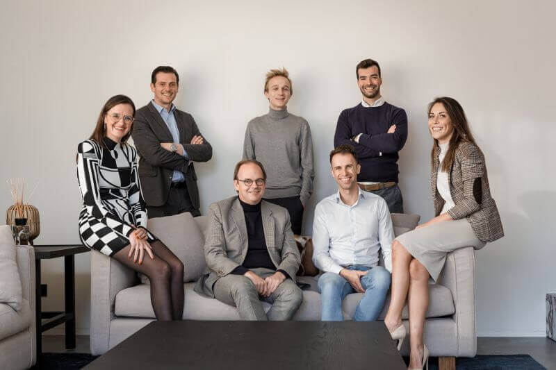 A group of people evergreenly posing on a couch.