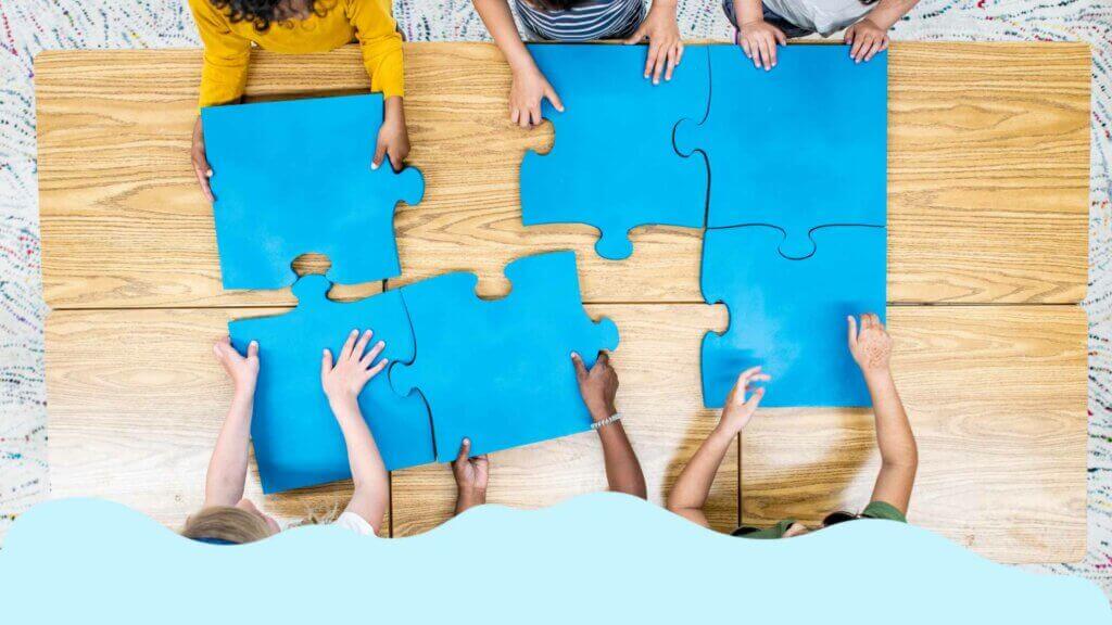 A group of children building a learning culture by putting puzzle pieces together on a table.