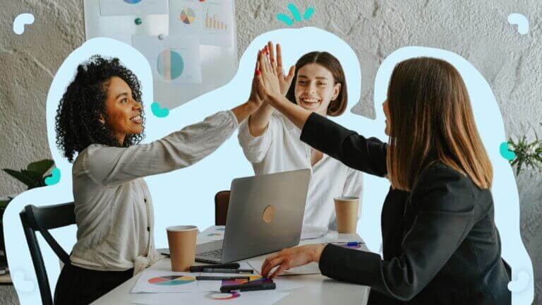 A group of women building a learning culture by giving each other a high five.
