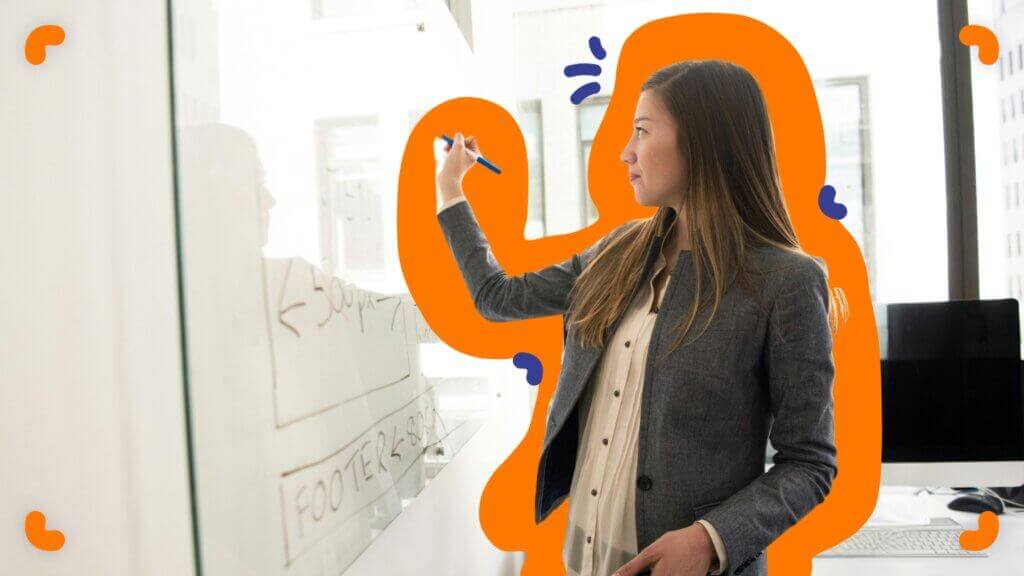 A woman is writing on a whiteboard as part of the EOS Process Component™.