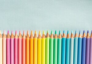 A row of colored pencils on a blue background representing the creative potential.