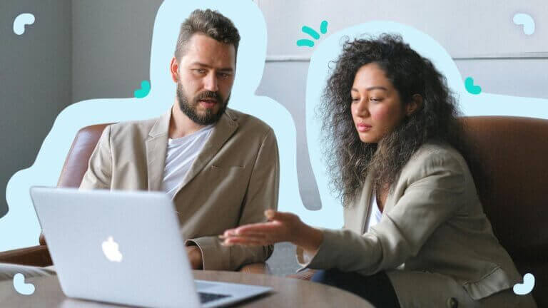 A man and woman are viewing a laptop, possibly discussing the difference between employee onboarding and training.