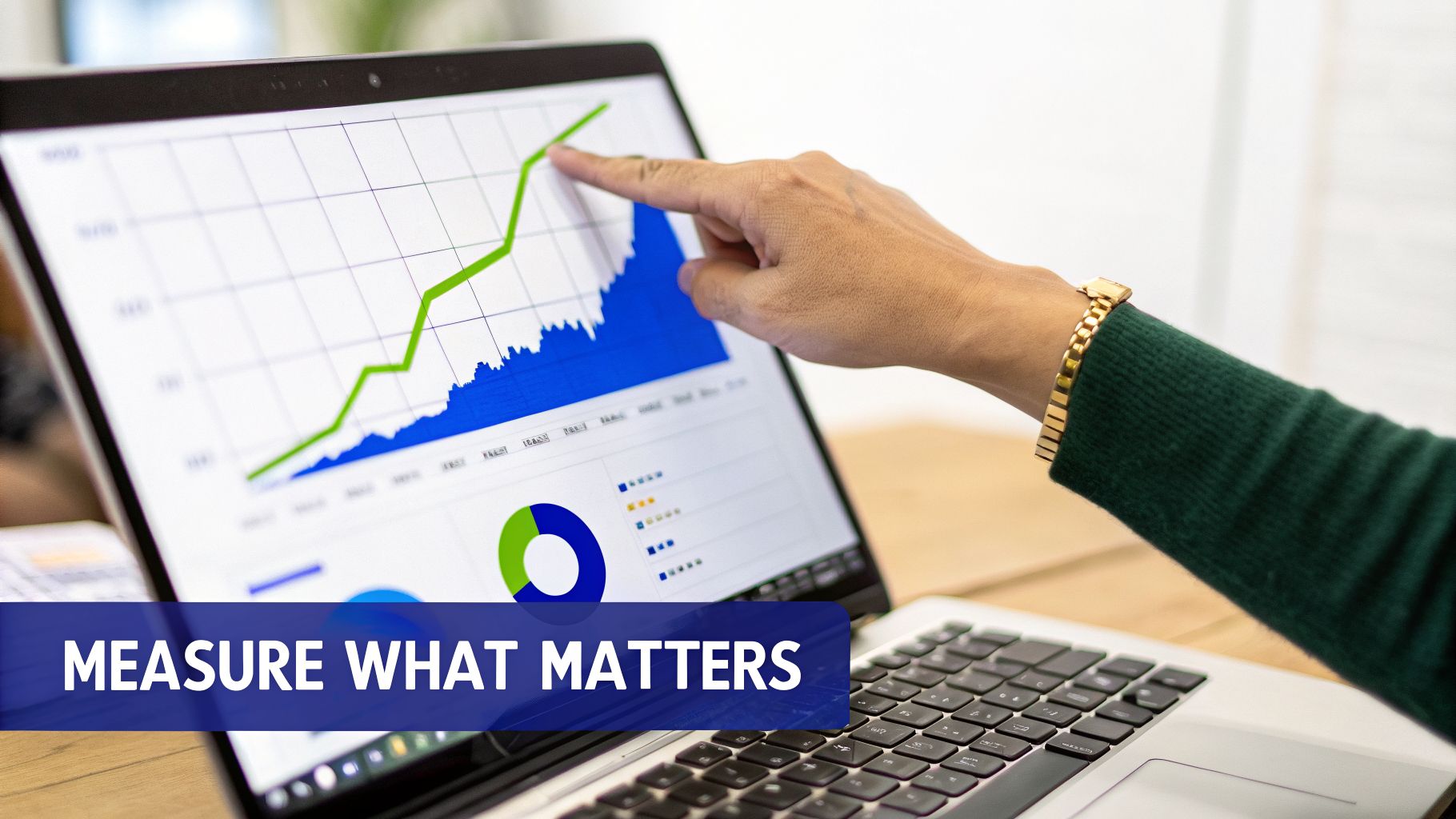 A hand points to a laptop screen displaying an upward trending graph and data charts for analysis.