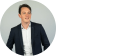 A man in a suit standing in front of a circle with the word "koen l" representing knowledge.